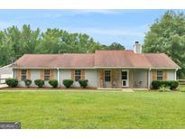 Charming single-story home with a well-maintained lawn, inviting porch with swing, and beautiful green trees at 552 New Hope Rd, Mcdonough, GA 30252