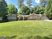 Charming home features a well-manicured lawn, mature trees and inviting curb appeal at 2062 Valiant Ne Dr, Atlanta, GA 30345