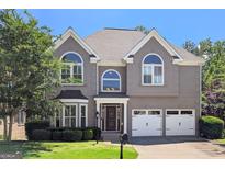 Charming two-story home featuring an attached two-car garage and well-manicured front lawn at 4527 Village Springs Run, Dunwoody, GA 30338