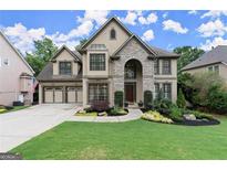 Beautiful two-story home with a three-car garage and professionally landscaped front yard at 7059 Hunters Rdg, Woodstock, GA 30189