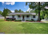 Charming home features a well-manicured lawn, an inviting porch, and delightful landscaping for great curb appeal at 1130 Rawlings Dr, Rutledge, GA 30663