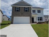 Two-story home boasts brick and siding, a two-car garage, and a well-manicured front yard at 173 Aster Ave, Locust Grove, GA 30248