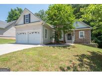 Charming home featuring a two-car garage, stone accents, and well-maintained front yard at 832 Windy Mill Ct, Temple, GA 30179