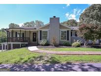 Charming home featuring a stone chimney, inviting front porch, and well-maintained landscaping at 8321 Banks Mill Rd, Douglasville, GA 30135