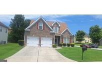 Charming brick home featuring a two-car garage and well-manicured lawn at 7314 Basalt Dr, Union City, GA 30291