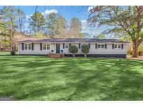 Charming ranch-style home with well-manicured lawn and inviting curb appeal at 308 Lee Thompson Rd, Moreland, GA 30259