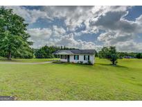 Charming single-story home featuring black shutters and a well-manicured lawn at 2809 South Ola Rd, Locust Grove, GA 30248