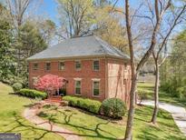 A two-story brick home has a beautiful lawn, landscaping, and a brick walkway to the front door at 2270 Emerald Dr, Jonesboro, GA 30236