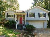 Charming home featuring large windows, stone accents, a red front door, and a two-car garage at 1306 Stonemont Rd, Auburn, GA 30011
