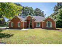 Charming brick home featuring a well-manicured lawn and inviting front entrance at 2303 Sharon Se Ct, Conyers, GA 30013