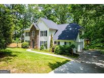 Charming two-story home with stone accents, landscaped yard, and a lush, wooded setting at 97 Coral Dr, Whitesburg, GA 30185