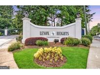 Landscaped entrance to Lenox Heights Condominiums with decorative lighting, mature trees, and manicured flower beds at 2119 Pine Heights Ne Dr, Atlanta, GA 30324