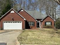 Charming single-Gathering brick home with a two-car garage and well-maintained front lawn at 12313 Riviera Dr, Fayetteville, GA 30215