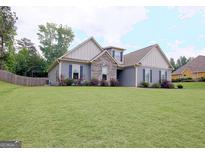 Charming one-story home boasts stone accents and a well-manicured lawn at 234 Thyme Leaf Way, Locust Grove, GA 30248