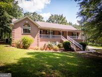 Charming brick home features a lovely front porch, well-manicured lawn, and inviting curb appeal at 1655 Stacia Dr, Covington, GA 30016