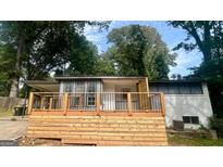 Charming home featuring a new wooden deck with black metal railings at 6072 Holiday Blvd, Forest Park, GA 30297