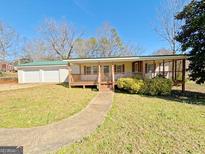 Charming single-story home with a covered porch and a detached two-car garage at 36 Reese St, Grantville, GA 30220