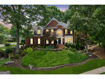 Stately brick home featuring manicured landscaping, shuttered windows, and a welcoming front porch at 750 Highview Ct, Woodstock, GA 30189