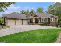 Charming home featuring a three-car garage, well-manicured lawn, and stone accents at 115 Edgewood Pkwy, Fayetteville, GA 30215