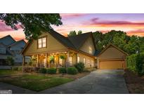 Charming home boasts a covered front porch with inviting string lights and manicured landscaping at 3007 Brush Arbor Xing, Mcdonough, GA 30252