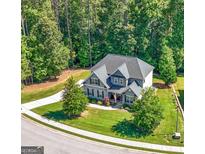 Stunning aerial view of home with a large manicured lawn, beautiful landscaping and a long driveway at 130 Edgewater Trl, Fayetteville, GA 30215