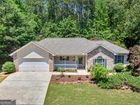 Charming single-story home with a well-manicured lawn and attached two car garage at 264 Keller Dr, Mcdonough, GA 30252