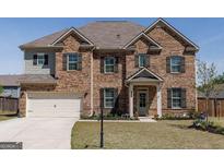 Charming two-story brick home with a well-manicured lawn and attached two-car garage at 7435 Ansley Park Way, Cumming, GA 30028
