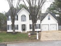 Charming two-story home with white siding, black shutters, and a well-manicured front yard at 7564 Mountain Ridge Ln, Lithonia, GA 30058