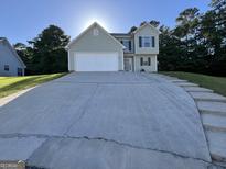 Charming two-story home with a spacious driveway and well-maintained lawn and nice green shutters at 5627 Isleworth Ct, Atlanta, GA 30349