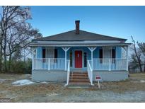 Charming blue single-story home featuring a brick stairs, red front door, and white porch at 1730 Spring Ne St, Conyers, GA 30012