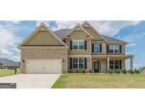 Two-story brick home with an attached two-car garage and a well-maintained lawn at 171 Osier Dr, Mcdonough, GA 30252