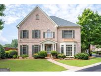 Charming brick home featuring a manicured lawn and lush landscaping at 3519 Preserve Se Dr, Atlanta, GA 30339
