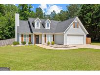 Charming two-story home with a well-manicured lawn, gray siding, and a spacious two-car garage at 75 Mcintosh Estates Ct, Sharpsburg, GA 30277