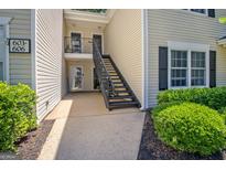 Attractive condo exterior with multiple doors, a stairwell, and a black and white address sign at 606 Ridgelake Dr, Peachtree City, GA 30269
