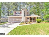 Charming two-story home with a unique turret and an attached two-car garage nestled among mature trees at 916 Forest Pointe, Jonesboro, GA 30238