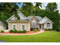 Charming single-story home with stone and stucco accents, manicured landscaping, and a welcoming front entrance at 115 Blue Grass Way, Oxford, GA 30054