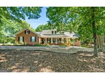 Charming brick home with a welcoming front porch and lush landscaping at 401 Riverwalk, Mcdonough, GA 30252