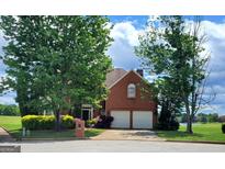 Charming brick home with a two-car garage, mature trees, and a well-maintained lawn at 690 Gateway Ct, Stone Mountain, GA 30087