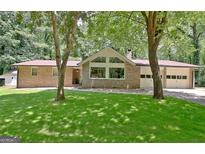 Beautiful brick home with large picture windows and a well-manicured lawn at 152 Dana Dr, Fayetteville, GA 30215
