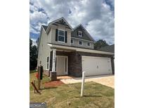 Charming two-story home featuring stone accents, a two-car garage, and a well-maintained front yard, creating instant curb appeal at 11142 Cornerstone Way, Hampton, GA 30228