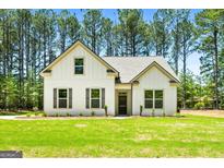 Beautiful home with white siding, black shutters, and a well-manicured lawn surrounded by many trees at 1547 South Bethany Rd, Locust Grove, GA 30248