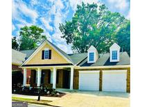 Charming brick home with a two-car garage, manicured lawn, and inviting front porch at 2200 Hickory Station Cir, Snellville, GA 30078