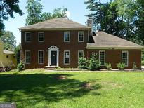 Two-story brick home featuring a well-manicured lawn and mature landscaping at 3683 Brown Dr, Decatur, GA 30034