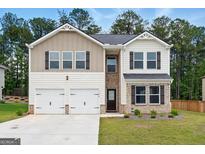 Charming two-story home features a two-car garage, neutral siding, and a well-manicured lawn at 768 Great Oak Place # 26, Villa Rica, GA 30180