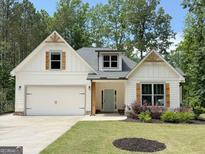 Charming single-story home featuring white siding, craftsman-style details, a two-car garage, and a well-manicured front yard at 3455 Henderson Dr, Cumming, GA 30041