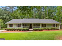 Charming home with a welcoming front porch, well-manicured lawn, and mature trees, exuding curb appeal at 145 Adams Ct, Fayetteville, GA 30214