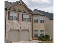 Traditional two-story home with a brick and siding exterior, attached two-car garage, and classic architectural details at 556 Emporia Loop, Mcdonough, GA 30253