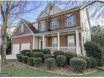 Charming two-story brick home with a welcoming front porch and well-manicured landscaping at 5280 Lakerock Sw Way, South Fulton, GA 30331