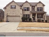 Charming two-story brick home with well-maintained landscaping and an attached two-car garage at 1690 Geranium Ln, Cumming, GA 30040