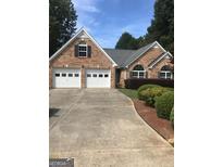 Charming brick home featuring a two-car garage and well-maintained landscaping at 436 Abbey Pl, Villa Rica, GA 30180